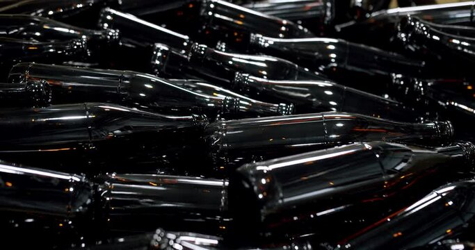 Close-up of brown bottles in a factory. A long row of glass bottles. Top view of a production line. Factory concept. Factory brewery concept.
