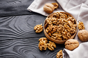 dried walnuts on a black rustic wooden background