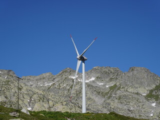 Fototapeta na wymiar San Gottardo Mountain Pass, Switzerland. A wind turbine working at high mountain. The generator and base of the wind turbines. Renewable energy. Electrical windmills. General contest of green energy