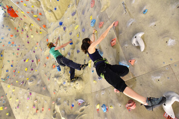 young sporty couple of climbers in a climbing hall