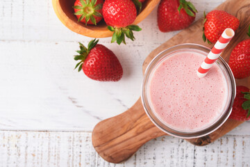 Strawberry smoothie. Vegan smoothie or milkshake from strawberry, banana and mint on white wooden table background. Clean eating, alkaline diet. Top view. Mock up.