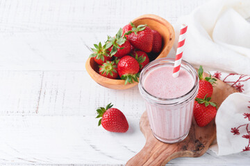 Strawberry smoothie. Vegan smoothie or milkshake from strawberry, banana and mint on white wooden...