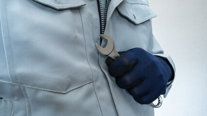 スパナを持った作業服の男性