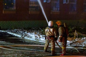 Russia Samara January 2020: EMERCOM employees extinguish a fire at night in winter.