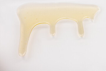 Honey flows. Drops of yellow syrup flow. Natural product and sweet drink. Isolated on white background.