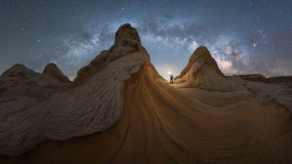 Anonymous traveler standing on stone on mountain with milky way on sky