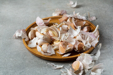 Garlic cloves and husks on a wooden plate food