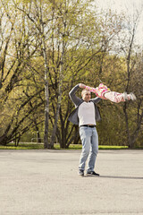 Dad is playing with his daughter in the backyard. Unwinds it around itself. Family, dad plays with his daughter on weekends