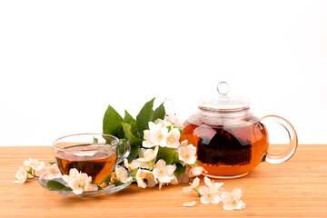 Composition with cup of jasmine tea and flowers on light background