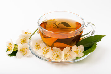 Composition with cup of jasmine tea and flowers on light background