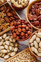 set of different nuts on a white wooden rustic background