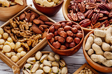 set of different nuts on a white wooden rustic background