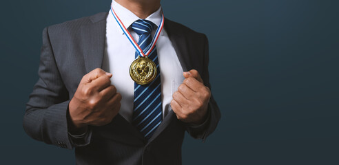 Plakat A business man holding a gold medal. Achieving success in business and achieving business goals.