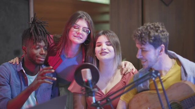 group of students singing a song at the microphone at the podcast university radio