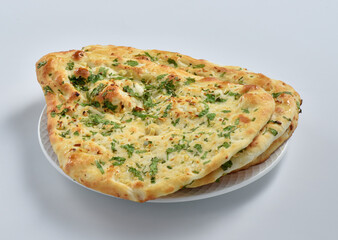 Garlic Naan Bread, A traditional Indian bread prepared with wheat flour, garlic, and coriander and baked in a vertical clay oven (tandoor), and then brushed with butter.