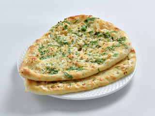 Garlic Naan Bread, A traditional Indian bread prepared with wheat flour, garlic, and coriander and baked in a vertical clay oven (tandoor), and then brushed with butter.