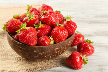 Fresh juicy ripe red strawberry in a brown coconut plate