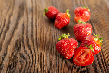 Fresh juicy red strawberry on a brown wooden background