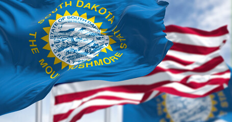The South Dakota state flag waving along with the national flag of the United States of America - obrazy, fototapety, plakaty