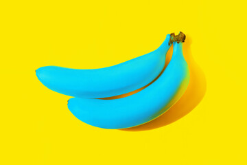 Two ripe blue bananas cast a shadow isolated on a bright color yellow background. Unusual colors,...