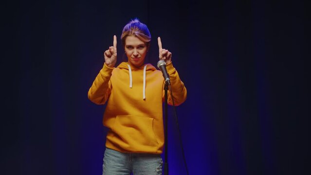 Talent contest. Woman showing funny magic tricks on stage, using hands. 