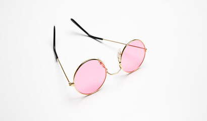 Sunglasses with pink color lens and gold round metallic frame isolated on white background