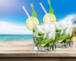 Two glasses of mojito and bar accessories. Mojito cocktail on a desk. Cocktail with lime and mint
