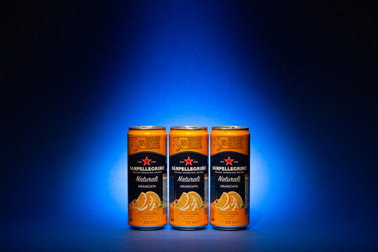 Three cans San Pellegrino Orange fruit mineral waters on the blue background