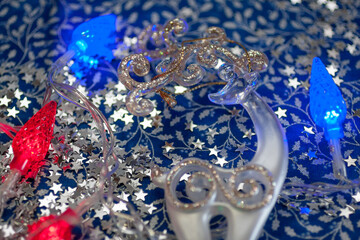 Closeup of the white deer with the golden horns, red and blue garland, silver stars on the blue and...
