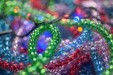 Closeup of the colorful tinsel with the garland. Christmas and New year background
