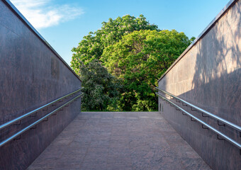 Urban sloping underpass with railings and perspective.