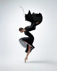 Deurstickers Elegant ballerina. A young graceful ballet dancer, dressed in pointes shoes demonstrates her dance skills. Power and refinement of classical ballet. © Alexander Y