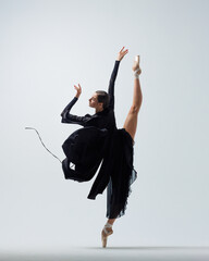 Elegant ballerina. A young graceful ballet dancer, dressed in pointes shoes demonstrates her dance skills. Power and refinement of classical ballet.