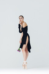 Elegant ballerina. A young graceful ballet dancer, dressed in pointes shoes demonstrates her dance skills. Power and refinement of classical ballet.