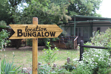 Panneau en bois location bungalow, arrière plan nature