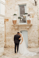 Vertical portrait of glad, cheerful romantic married couple, wedding. Overdressed, embracing in historical Italy town 