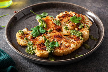 cauliflower steaks with herb sauce and spice. plant based meat substitute