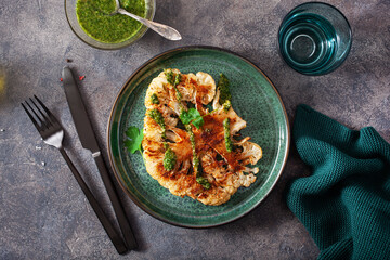 cauliflower steaks with herb sauce and spice. plant based meat substitute