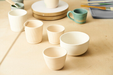 Mugs made of white clay are not glazed. Pottery course, clay school