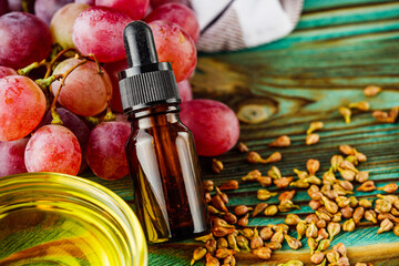 grape seed essential oil on a wooden rustic background