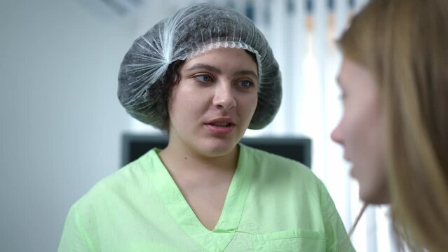 Expert Caucasian plus-size doctor talking with patient smiling. Portrait of confident young chubby gynecologist consulting woman in hospital indoors. Medicine and health care concept
