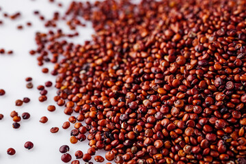red quinoa seeds on a white acrylic background