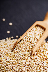 white quinoa seeds on a dark rustic background
