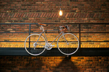 Modern bicycle hang on wall for decoration purpose with rustic brick background