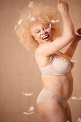 Obraz premium Feathers Falling On Confident Natural Albino Woman In Underwear Promoting Body Positivity