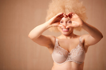Studio Shot Of Natural Woman In Underwear Making Heart Shape With Hands Promoting Body Positivity