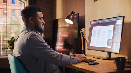 Young Handsome African American Man Working from Home on Desktop Computer in Sunny Stylish Loft...