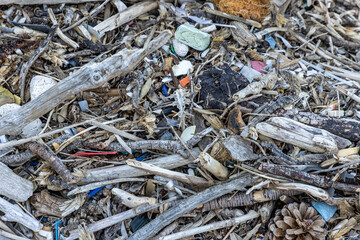 Plastic bottles and waste washed up on a beach by the incoming tide, covering the entire beach 