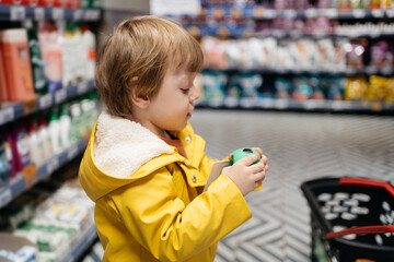 child in the market with a grocery cart buys a ball