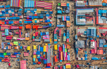 Aerial view of traditional village fair in Bangladesh. Colorful tents of temporary shops make it...